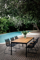 CLICK Dining black bamboo table & chairs near pool