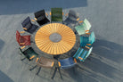 Dining table and colorful chairs arranged in a circle.