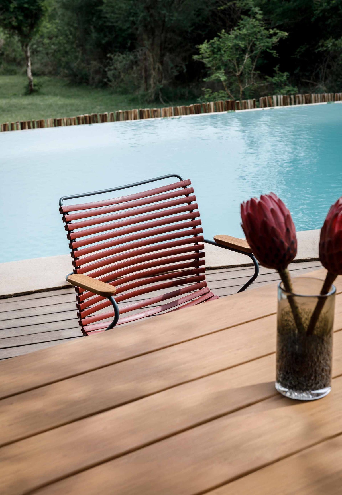 Dining chair and paprika flowers by pool