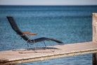 Black HOUE CLICK sunlounger on a pier overlooking the ocean.