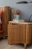 Wooden nightstand with books and lamp