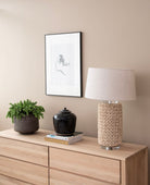 Interior decor with lamp, art, and plant on dresser