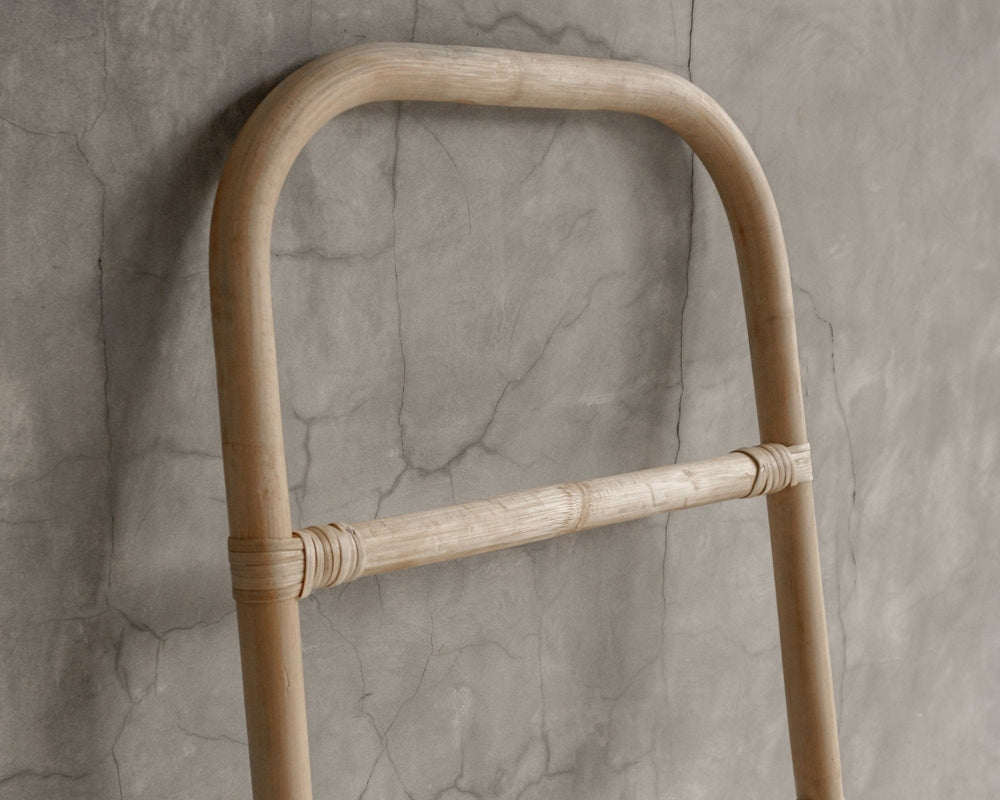 Close-up of a wooden ladder against a textured wall