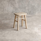 ELE143-1 wooden stool against a textured wall