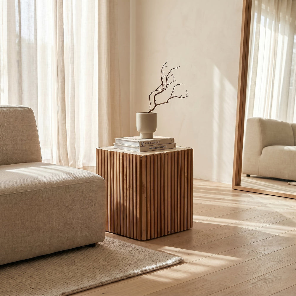 Modern living room with a wooden side table, beige armchair, and large mirror.