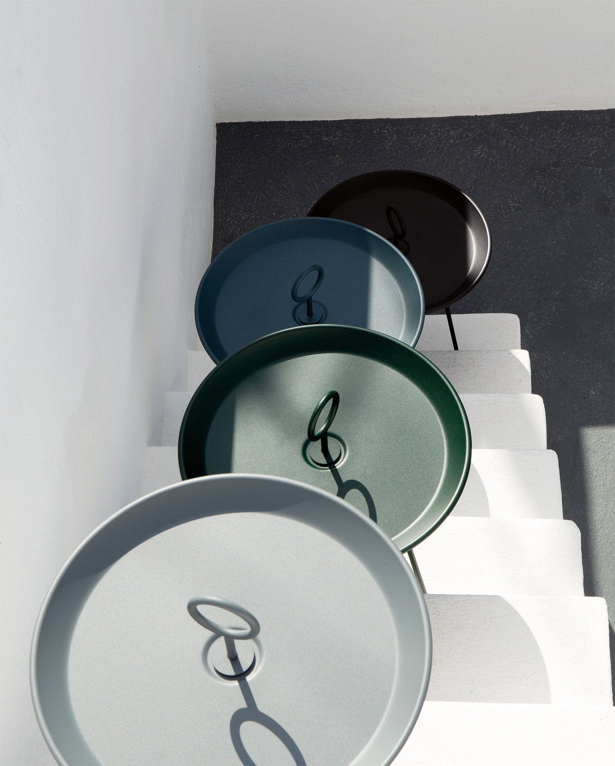 Four colored HOUE EYELET trays on stairs
