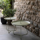 Pistachio eyelet tray tables on patio with stone wall