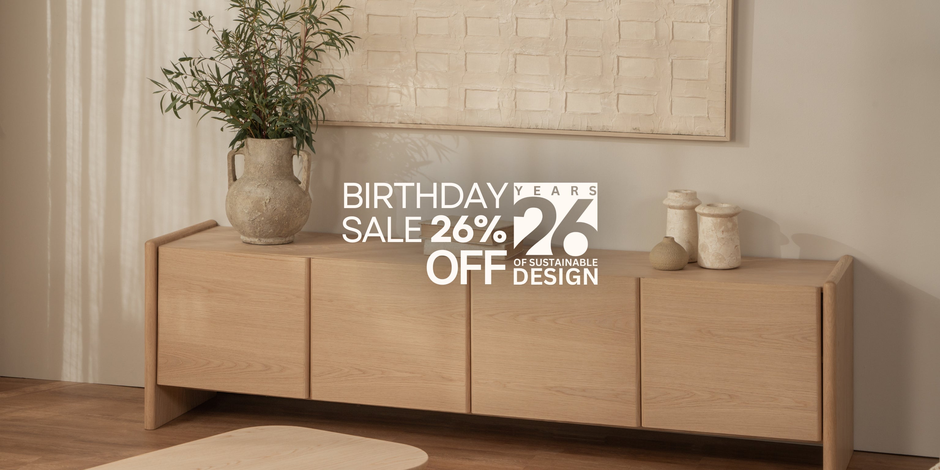 Wooden sideboard with decorative items in a room setting, featuring a birthday sale promotion.