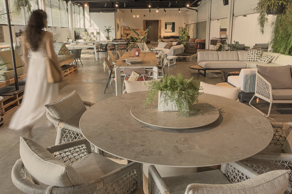 Modern outdoor seating area with tables, chairs, and decorative plants in a stylish setting.