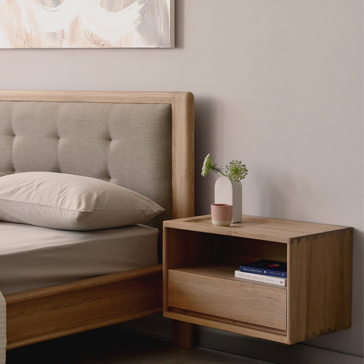 Wooden bed with upholstered headboard and nightstand in a bedroom setting.