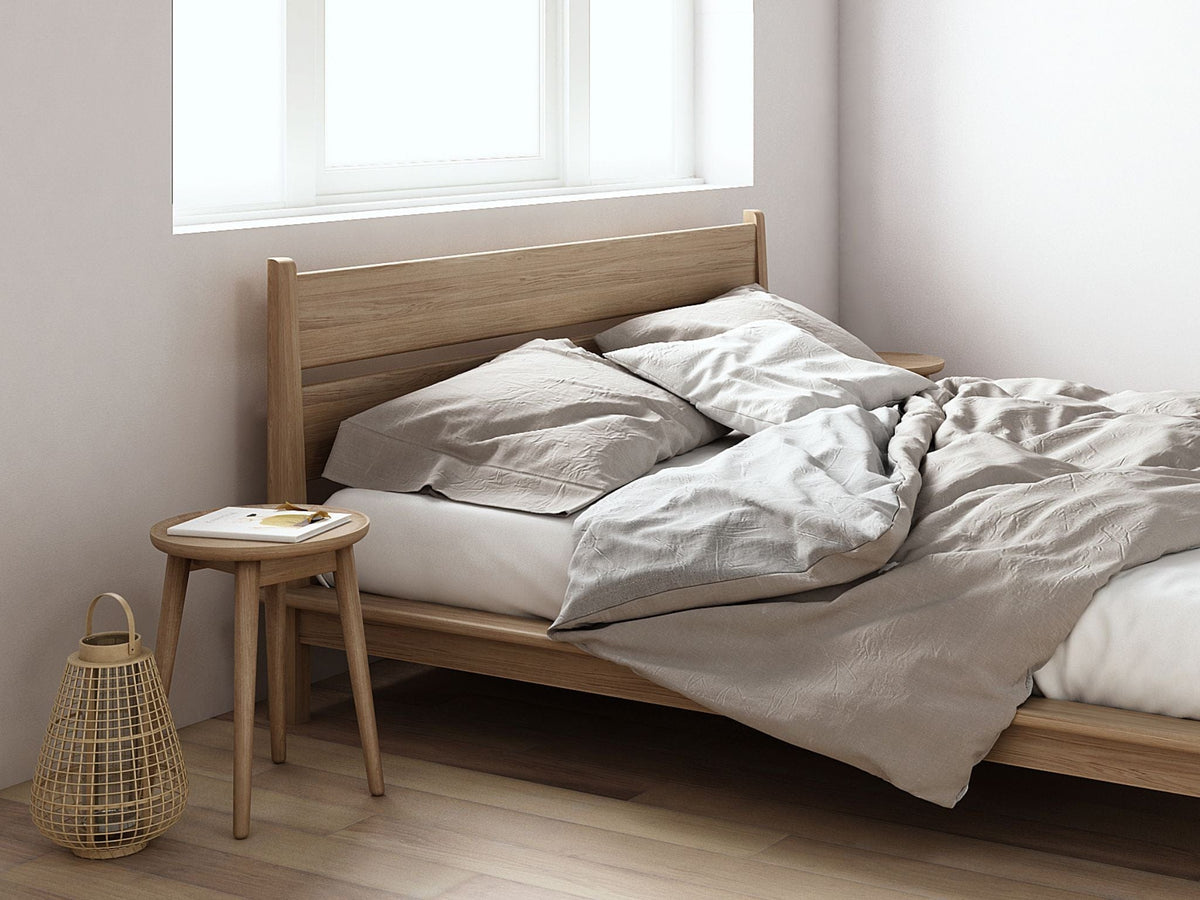 Bedroom with wooden bed and linen bedding