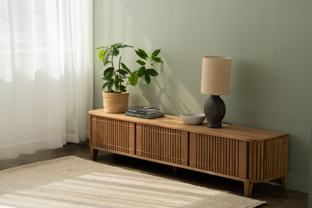 Wooden KKP17O_4 TV stand with lamp, plant, and accessories.