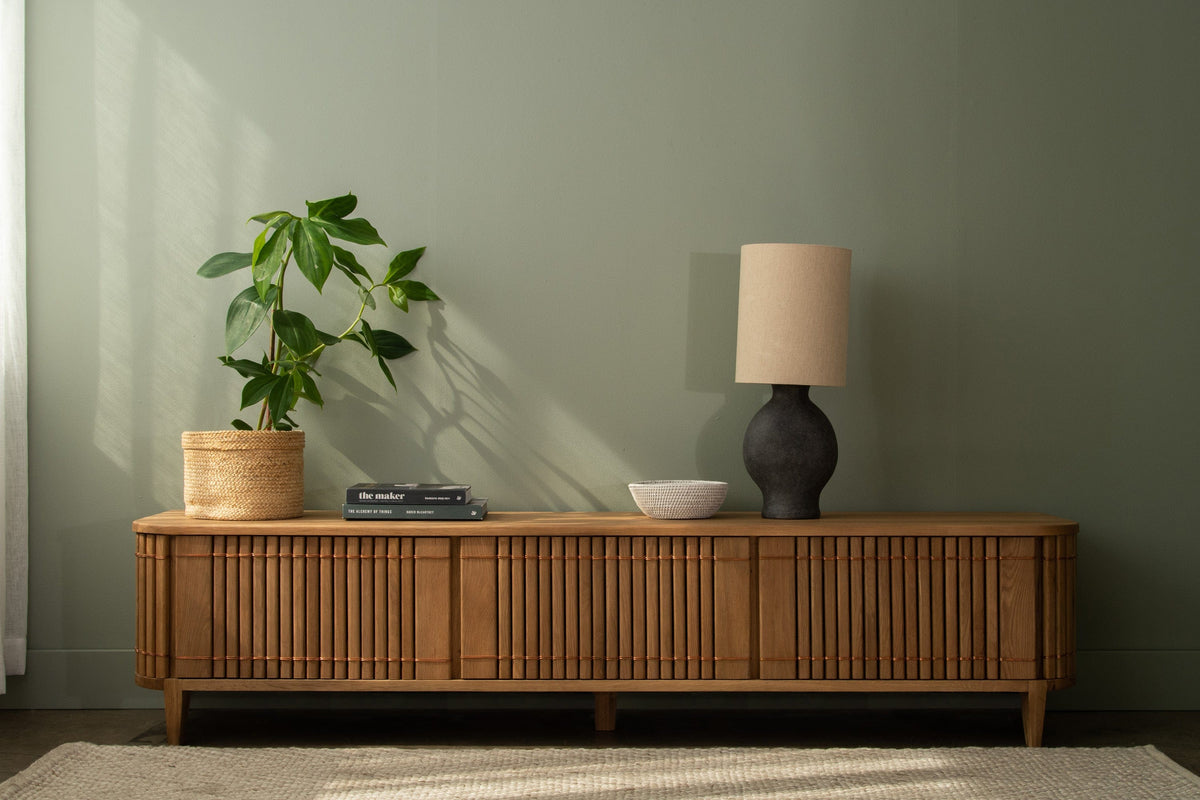Wooden TV stand with lamp and plant