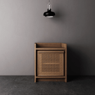 Wooden cabinet with woven door under pendant light