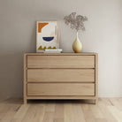 Modern wooden dresser with art and vase.