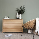 KSD013O wooden dresser, vase decor, and wicker chair.