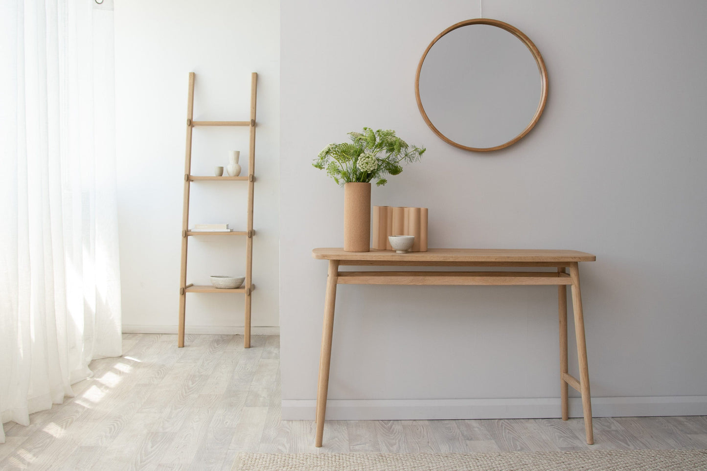 Modern wood console table with mirror, ladder, and flowers