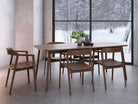 Wooden dining table and chairs with a winter view.