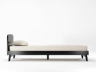 Black bed frame with mattress and pillow