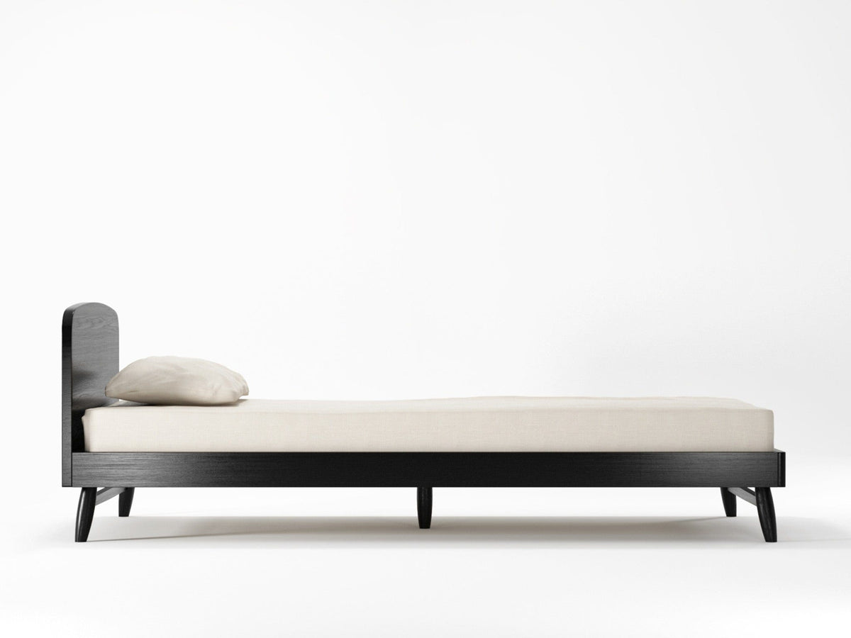 Black bed frame with mattress and pillow