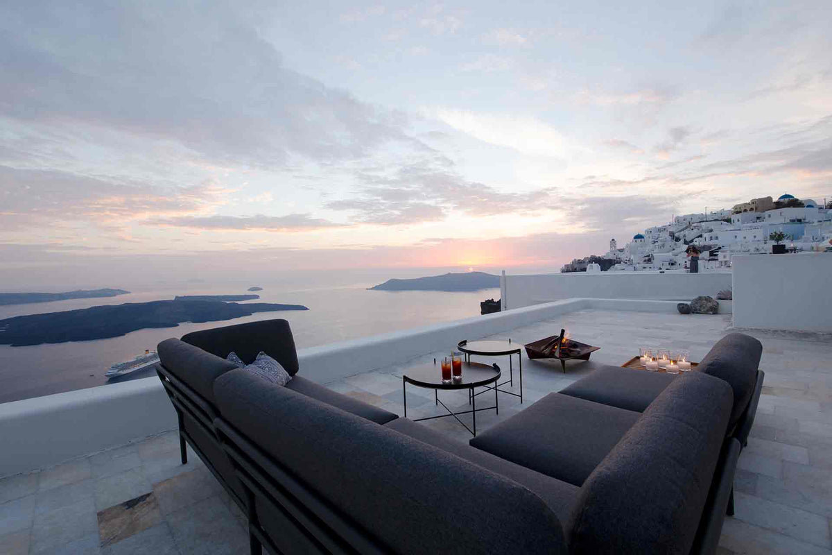 Grey outdoor sofa with caldera view at sunset