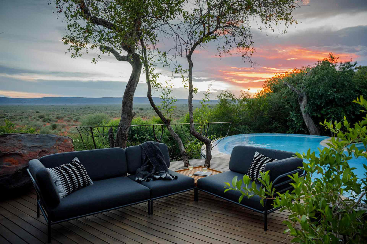Sooty grey HOUE outdoor sofa set by pool at sunset