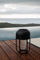Black outdoor rain lamp on wooden table