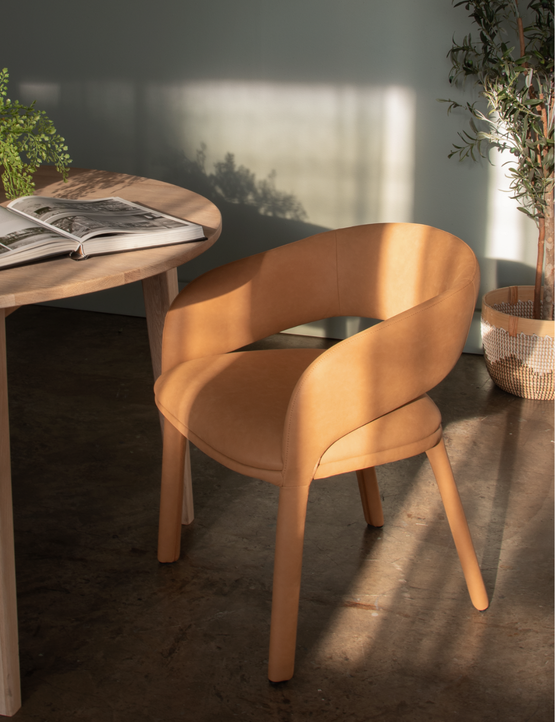 Brown chair and wooden table with a magazine in a softly lit room.