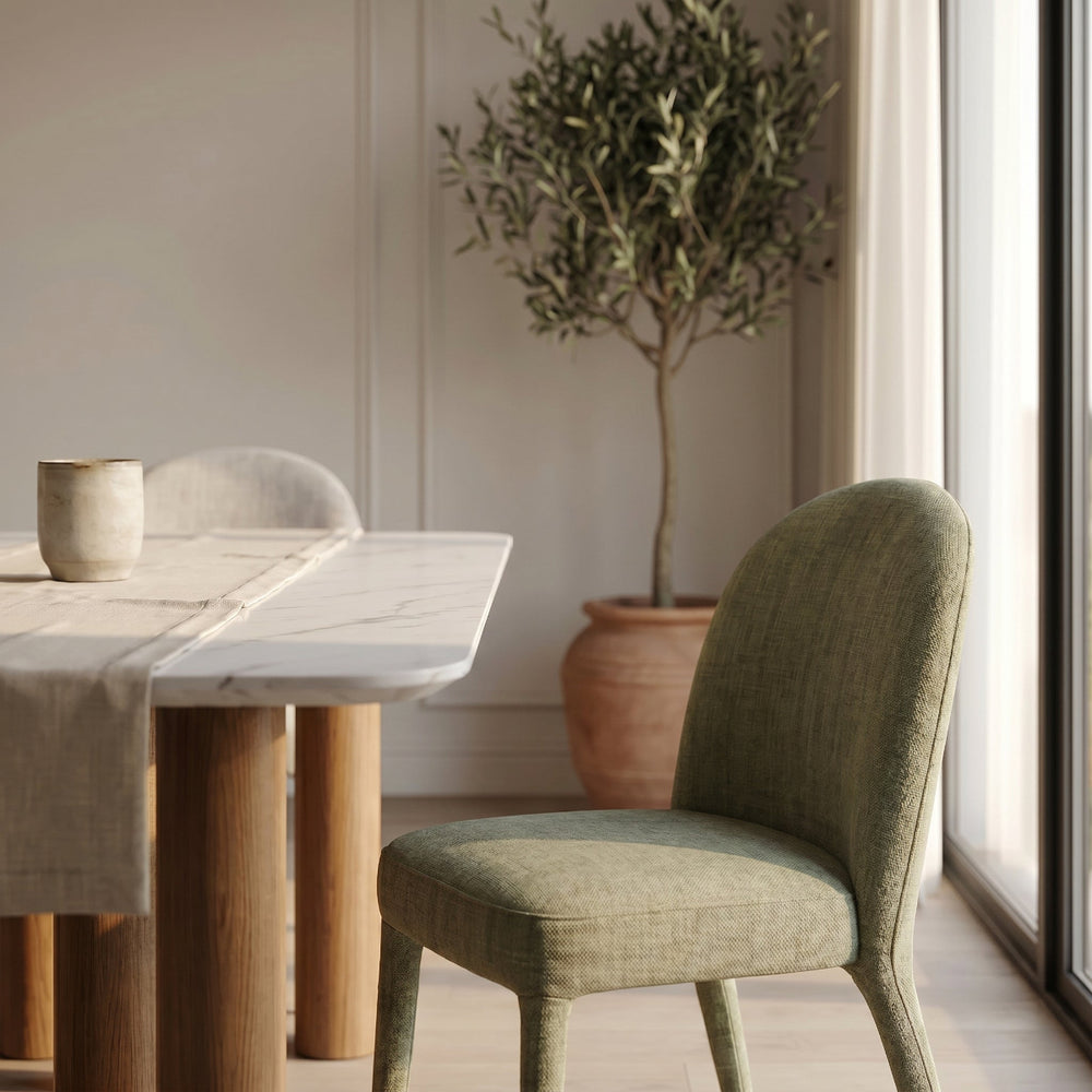 Dining room with wooden table, green chair, and potted plant.