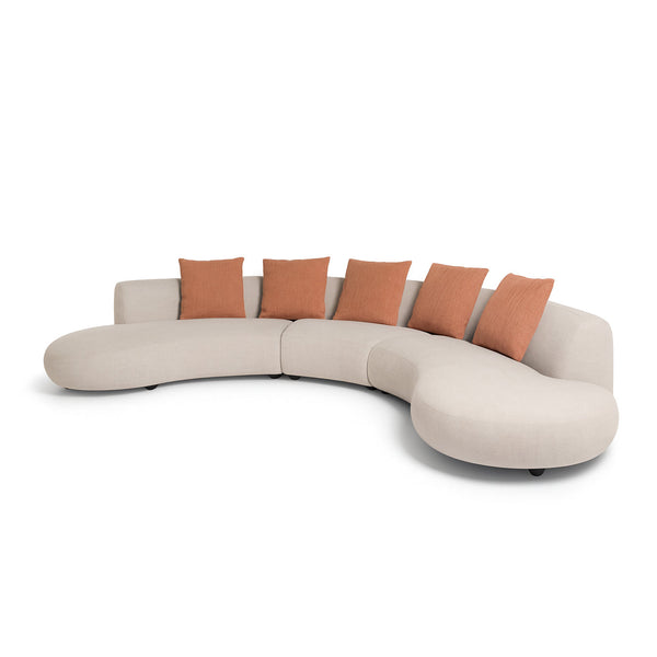 Curved beige sofa with orange cushions on a white background