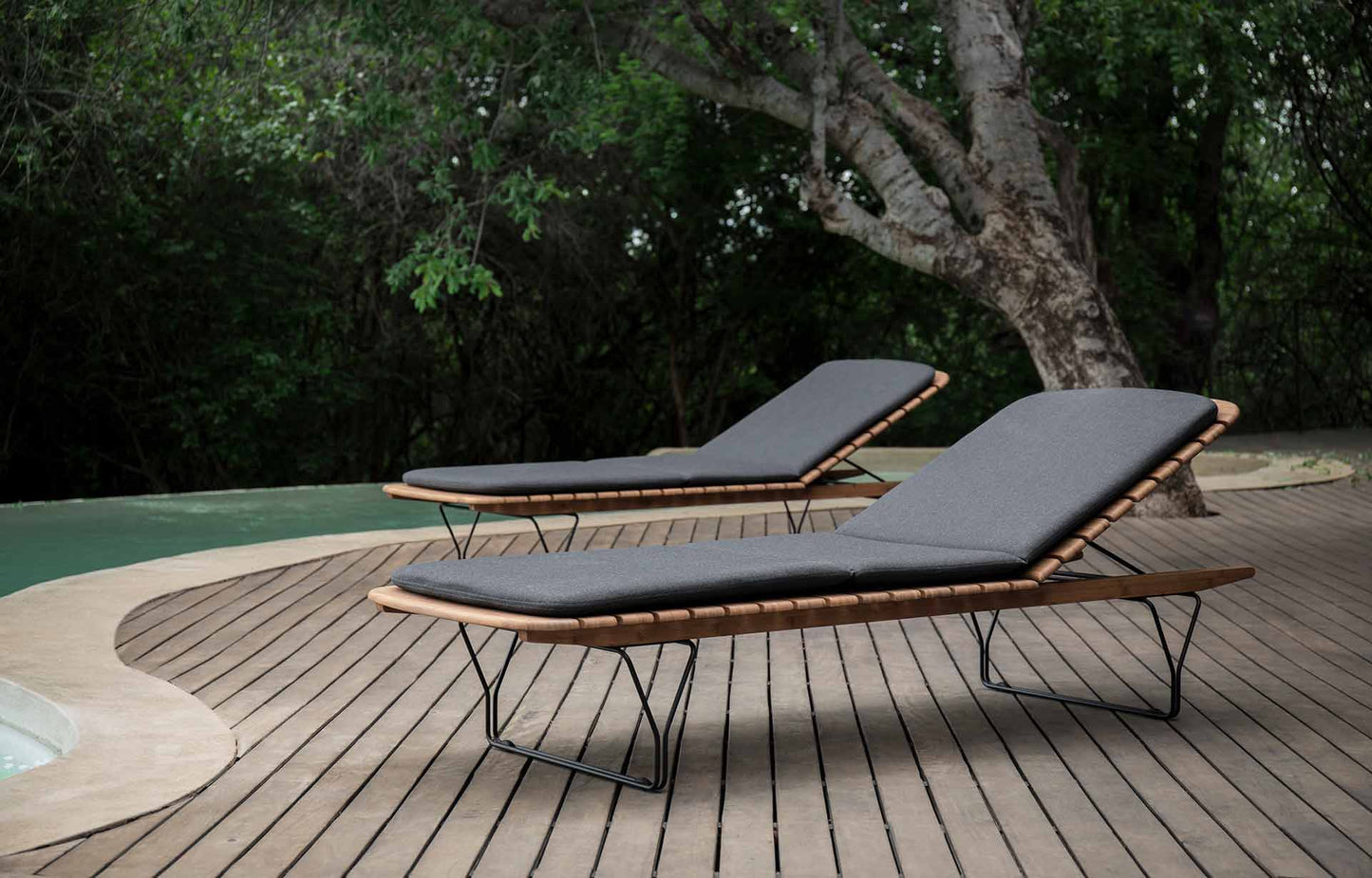 two lounge chairs by pool