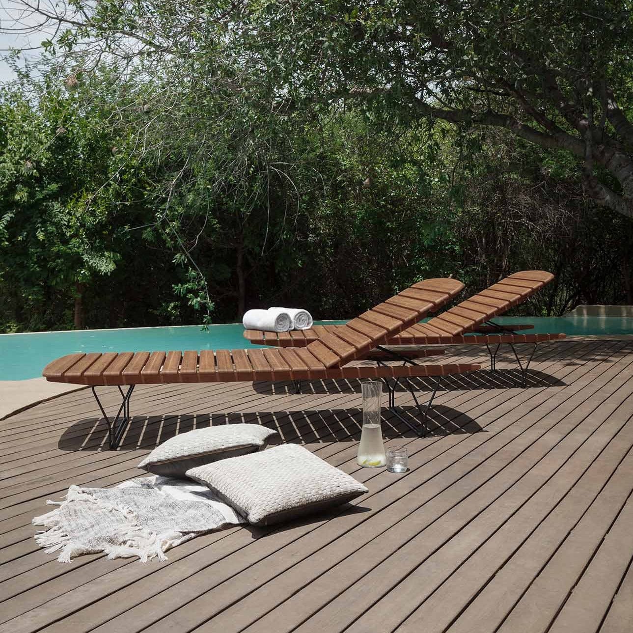 Wooden chaise lounges by pool