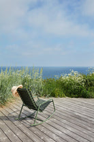 ReCLIPS olive green rocking chair by HOUE on deck overlooking ocean