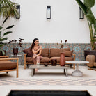 Woman on STICKS 2-seater sofa in outdoor patio