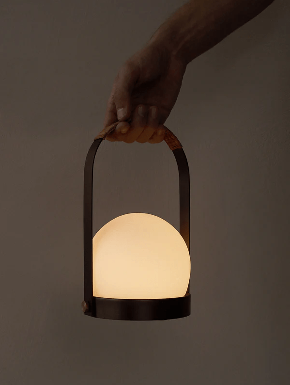 Hand holding glowing orb lantern