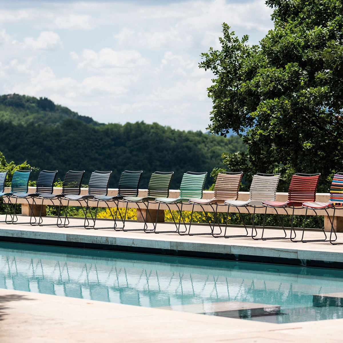Colorful armless chairs by a pool