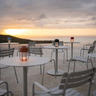 White outdoor tables with pico alua lanterns at sunset