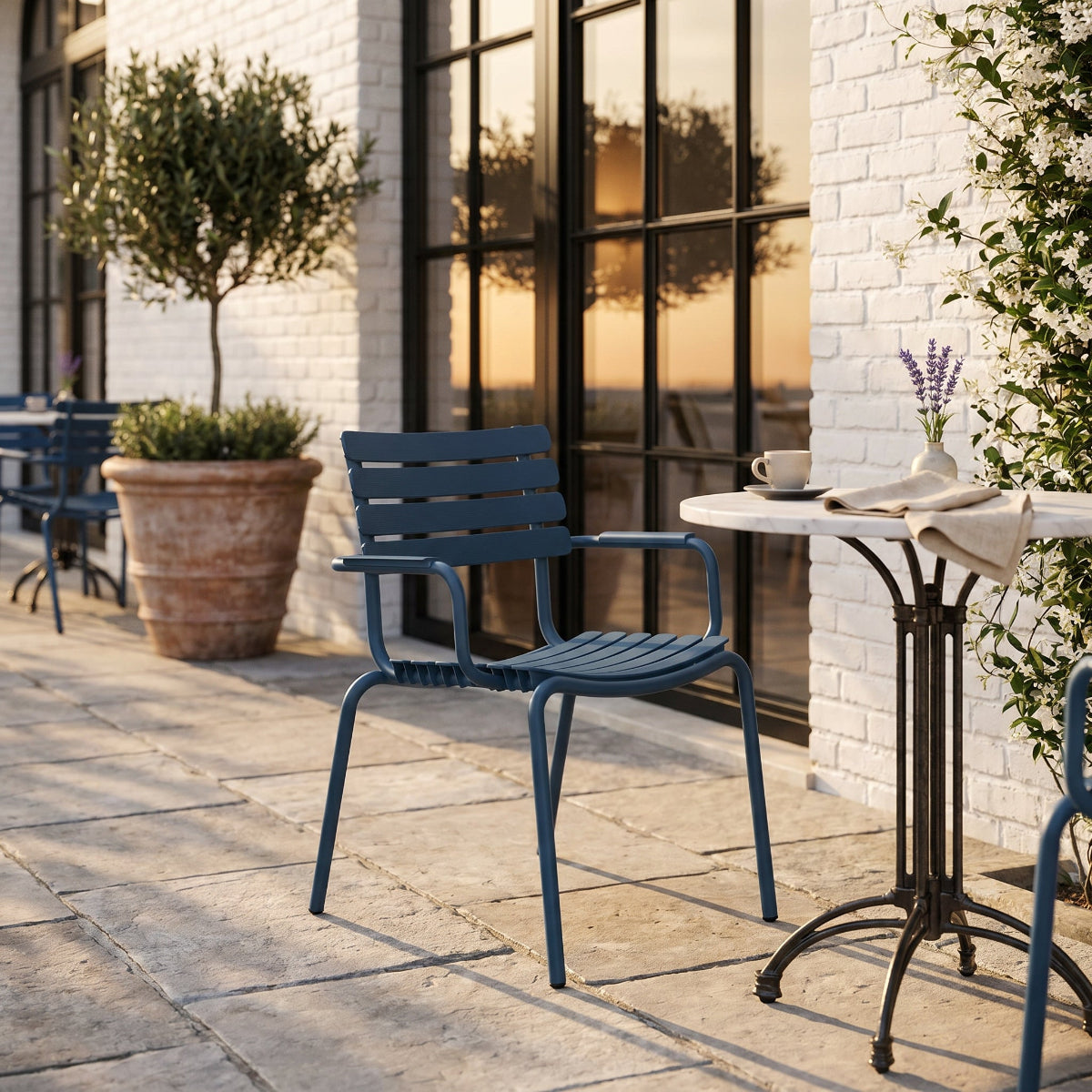 Blue chair and table set on a patio with a building in the background