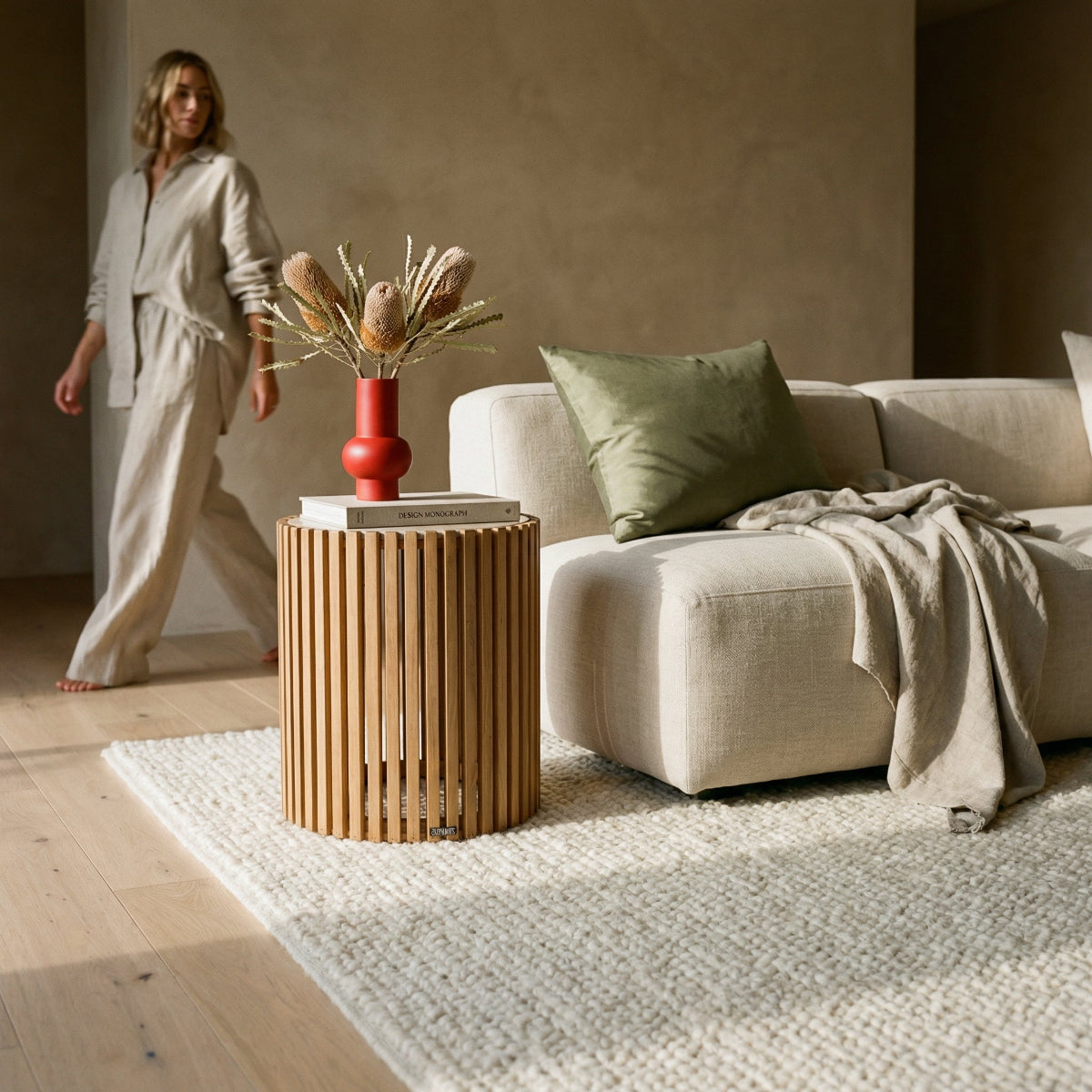Living room with a beige sofa, wooden side table, and decorative elements.
