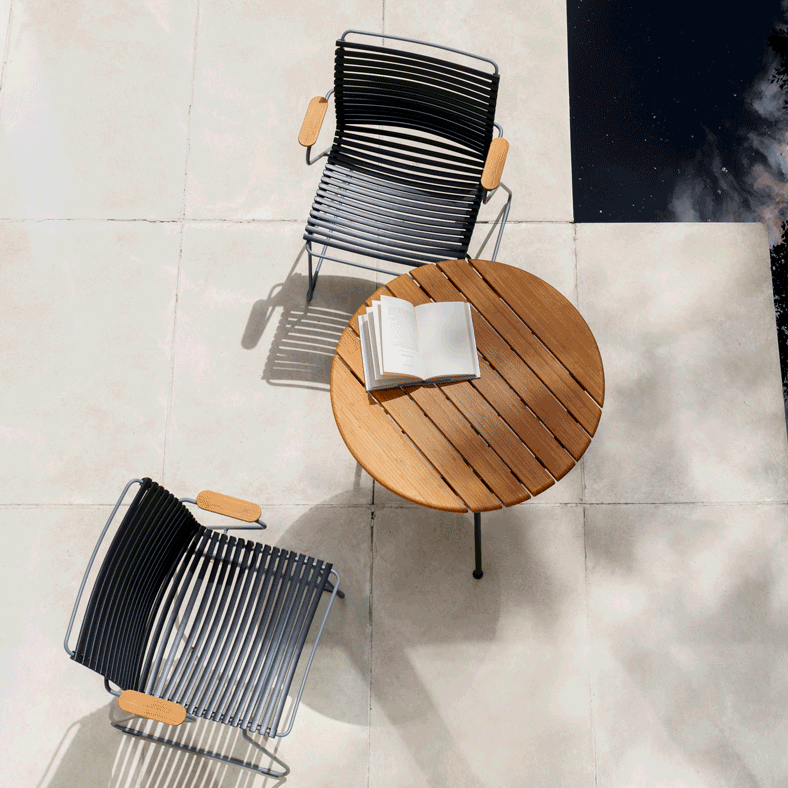 Top down view of a small round table with two black outdoor chairs