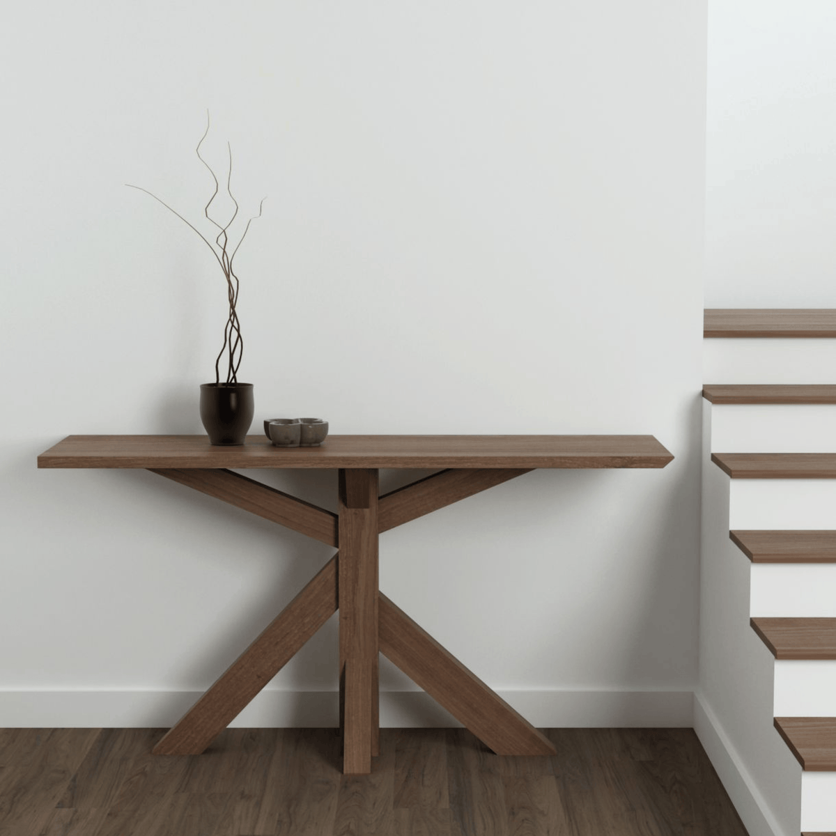 Wooden console table with decor next to stairs.