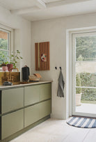 Kitchen with KANAMEDSIENNASMLROSE cabinets and outdoor view.