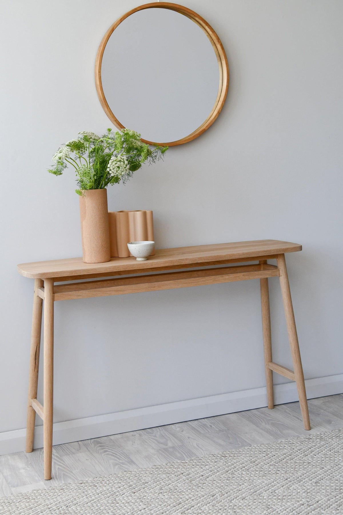 Wooden console table with mirror and decor.