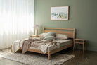 Wooden bed frame in bedroom with neutral tones