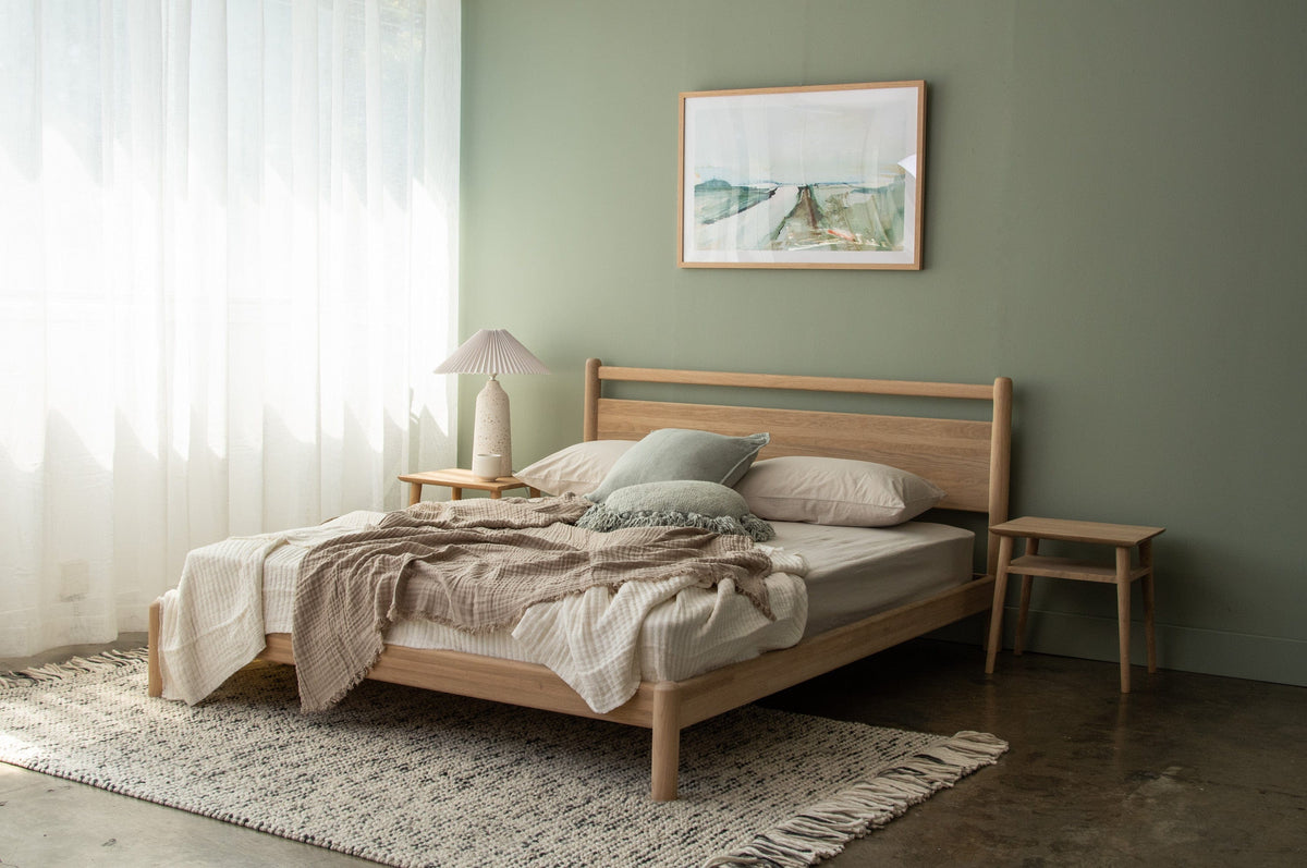 Wooden bed frame in bedroom with neutral tones