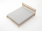 Wooden bed frame with a gray mattress